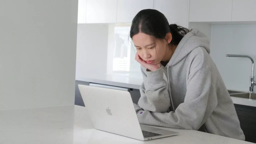 Woman using a laptop at home, illustrating consumer AI privacy and security risks.